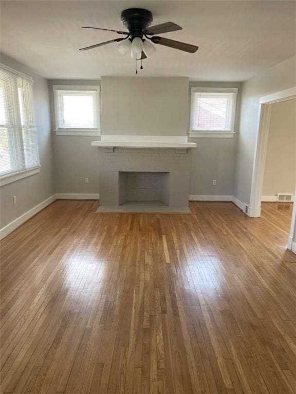 846 Neely Heights Ave, Coraopolis, PA 15108 - unfurnished living room featuring a ceiling fan, a wealth of natural light, wood-type flooring, and a fireplace with flush hearth