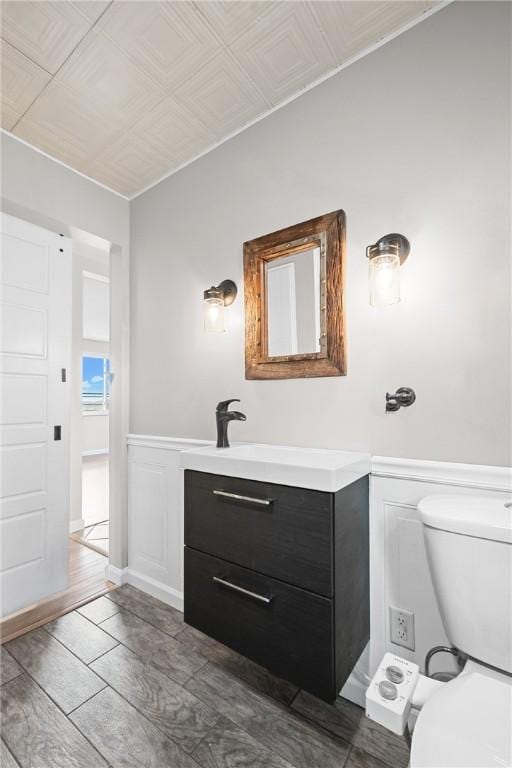 3606 Churchview Ave, Baldwin Boro, PA 15236 - bathroom featuring toilet, a decorative wall, vanity, and a wainscoted wall