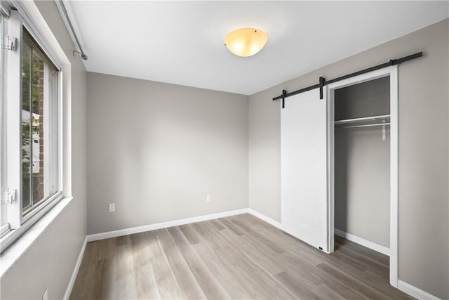 3606 Churchview Ave, Baldwin Boro, PA 15236 - unfurnished bedroom featuring baseboards, a closet, a barn door, and wood finished floors