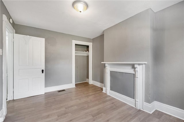 5126 Blair St, Hazelwood, PA 15207 - unfurnished living room with a fireplace, baseboards, light wood-type flooring, and visible vents