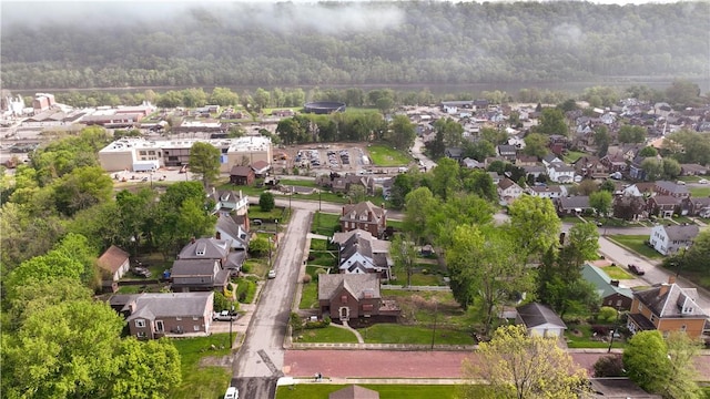 drone / aerial view featuring a wooded view and a residential view