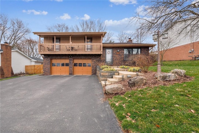 view of front of home with a balcony, brick siding, an attached garage, a front yard, and aphalt driveway