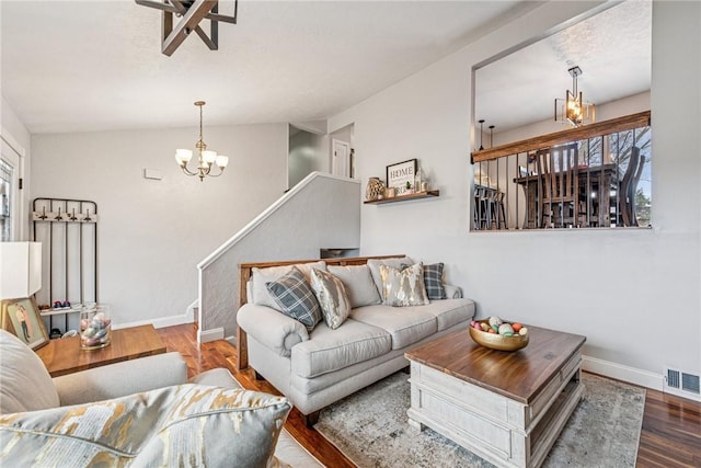 living room with a notable chandelier, baseboards, visible vents, and wood finished floors