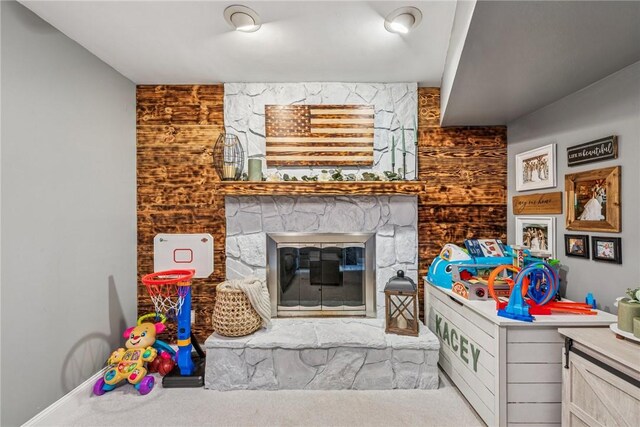 playroom featuring a fireplace, carpet floors, and baseboards