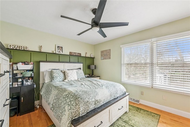 bedroom featuring light wood-style flooring, baseboards, and a ceiling fan