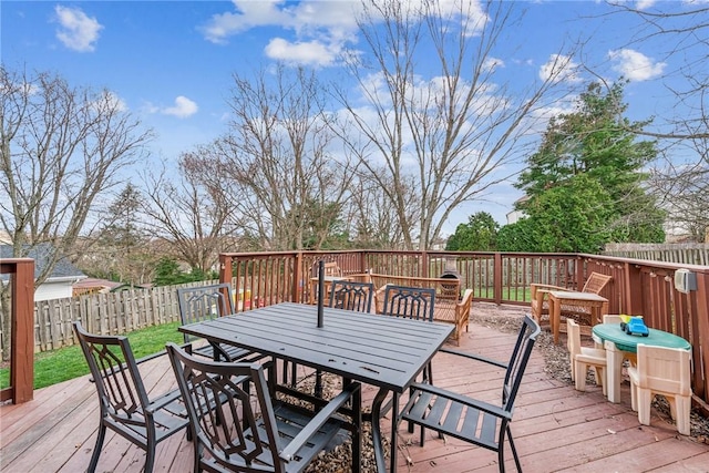 wooden deck with outdoor dining area and a fenced backyard