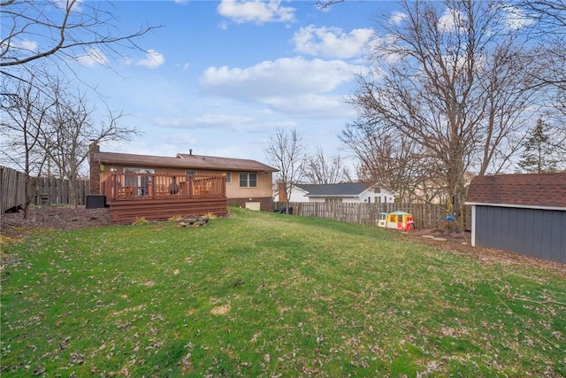 view of yard with a fenced backyard, a wooden deck, a storage unit, and an outdoor structure