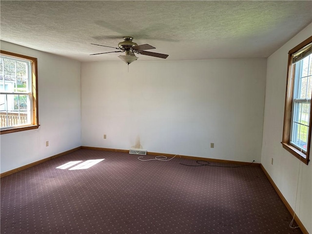 spare room with carpet floors, a healthy amount of sunlight, and visible vents