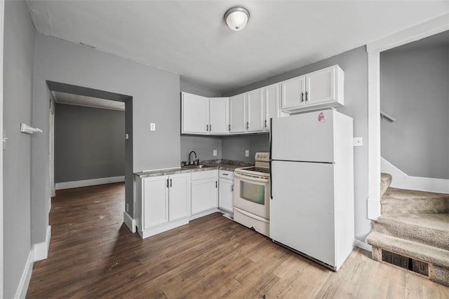 kitchen featuring white appliances, dark wood finished floors, white cabinets, and a sink