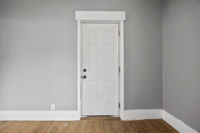 empty room with baseboards and wood finished floors