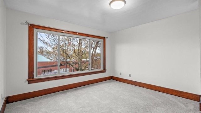 carpeted spare room featuring baseboards