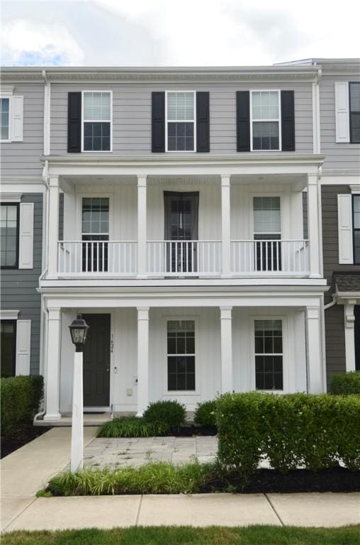 view of property featuring board and batten siding, a porch, and a balcony