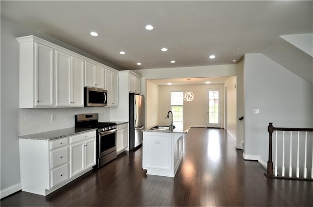 kitchen with white cabinetry, stainless steel appliances, dark wood-type flooring, and a sink