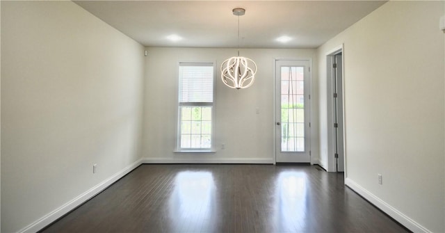 doorway featuring baseboards, dark wood-style floors, and a notable chandelier