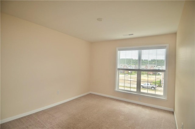spare room with light colored carpet and baseboards