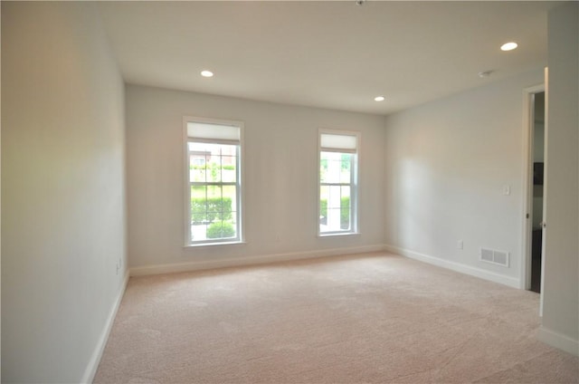 empty room with light colored carpet, baseboards, visible vents, and recessed lighting
