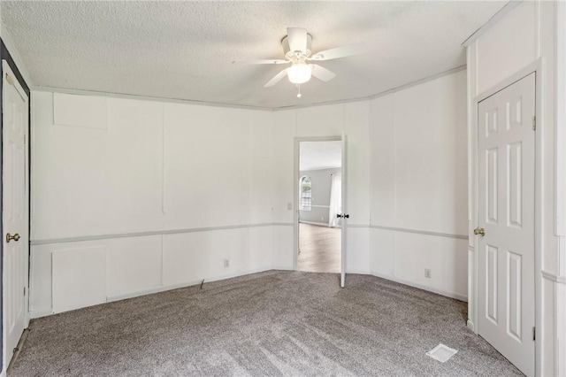 unfurnished bedroom with a textured ceiling, a ceiling fan, and carpet floors
