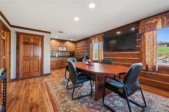 dining space with light wood-style flooring, baseboards, ornamental molding, and recessed lighting