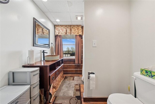 bathroom with a drop ceiling, toilet, visible vents, vanity, and wood finished floors