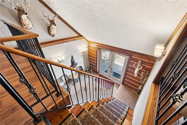 stairway with a textured ceiling and wood finished floors