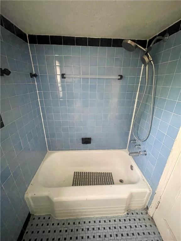 full bathroom featuring washtub / shower combination and tile patterned floors