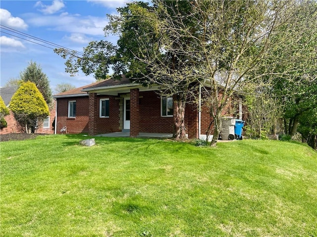 view of front of home featuring brick siding and a front yard