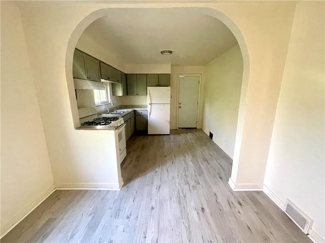 5850 Heberton Dr, Penn Hills, PA 15147 - kitchen featuring white appliances, a sink, light wood-type flooring, under cabinet range hood, and light countertops