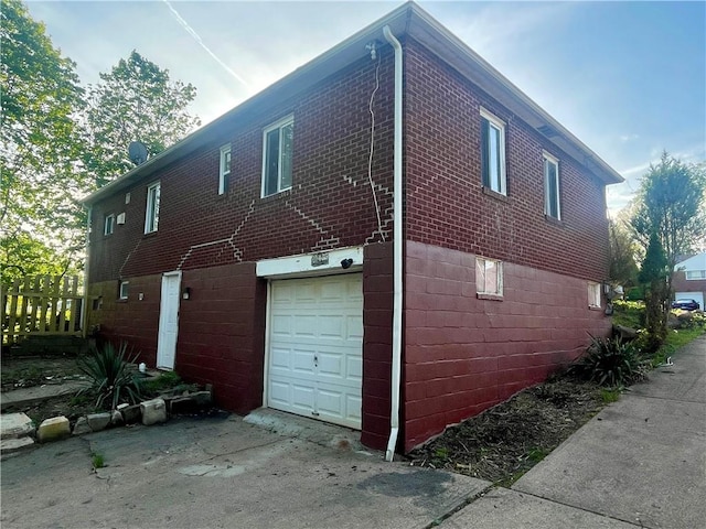 view of side of home featuring brick siding and a garage