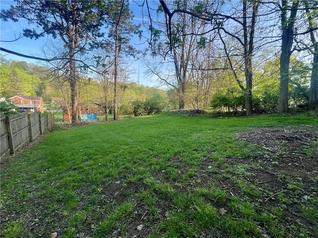 view of yard featuring fence and a view of trees