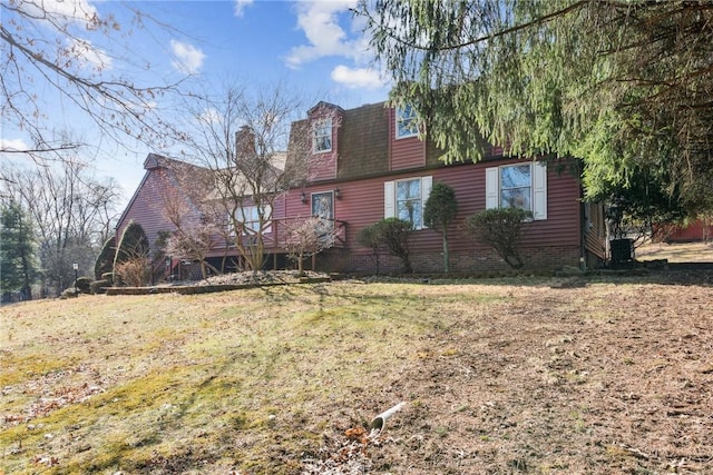 exterior space featuring roof with shingles, a deck, and a lawn