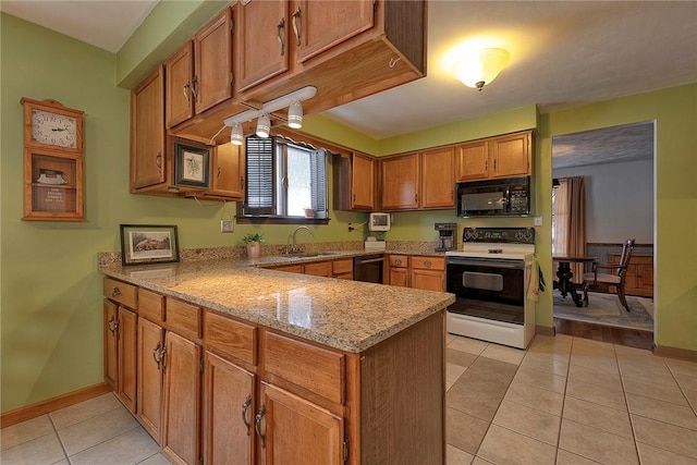 kitchen featuring a sink, a peninsula, brown cabinetry, light tile patterned flooring, and black appliances