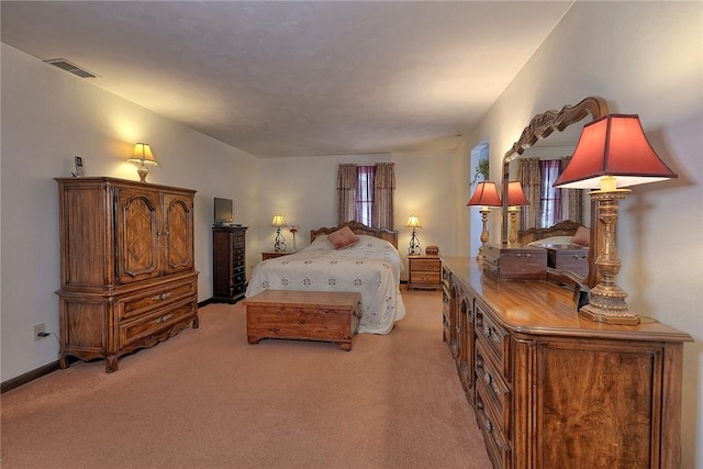 bedroom featuring baseboards, visible vents, and light colored carpet
