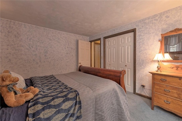bedroom featuring baseboards, carpet floors, a closet, and wallpapered walls