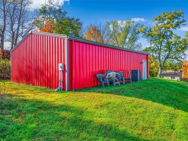 view of pole building with a yard and central AC unit
