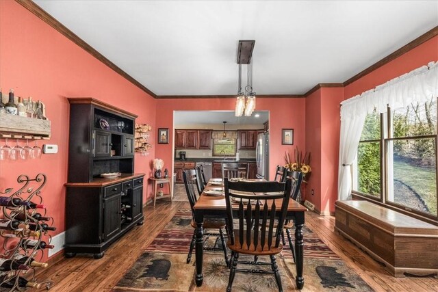dining room with crown molding, baseboards, and dark wood-style floors