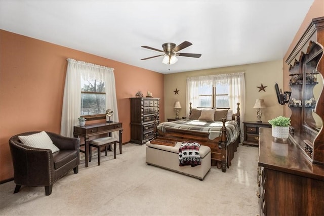 bedroom featuring light colored carpet and a ceiling fan