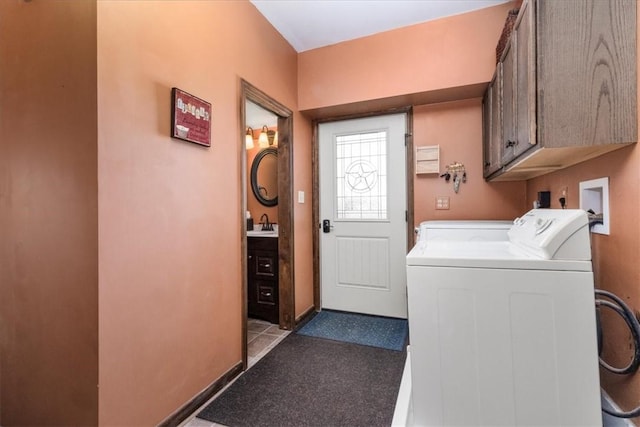 clothes washing area with washing machine and clothes dryer, a sink, and cabinet space