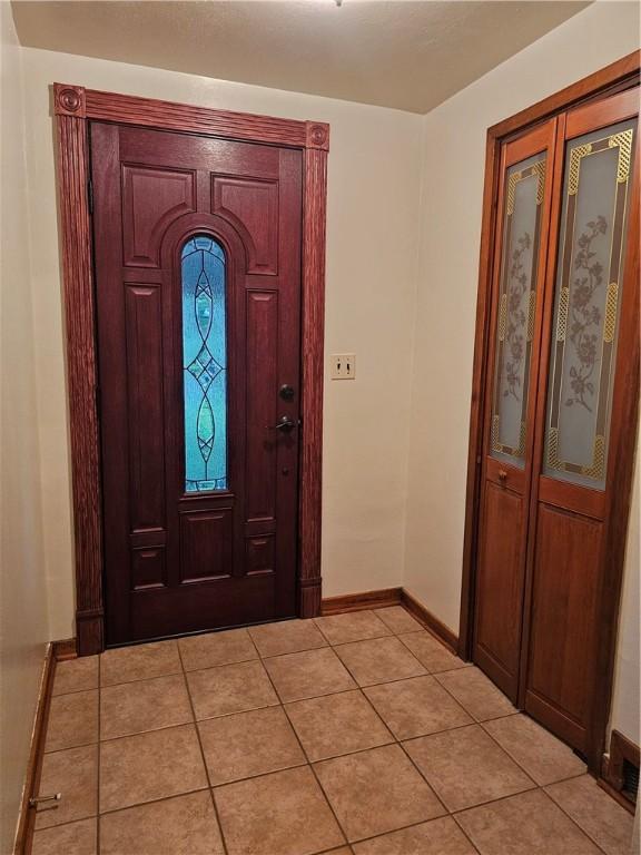 entrance foyer with baseboards and light tile patterned floors