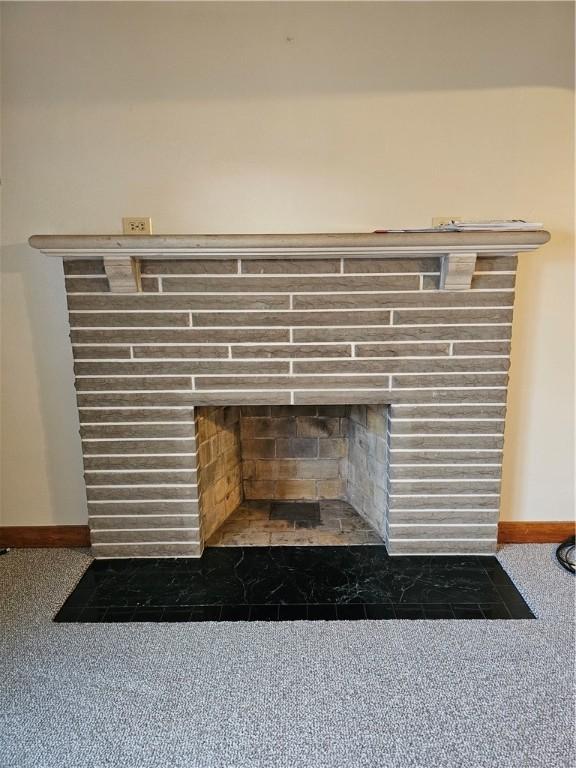 room details with baseboards, a fireplace with flush hearth, and carpet floors