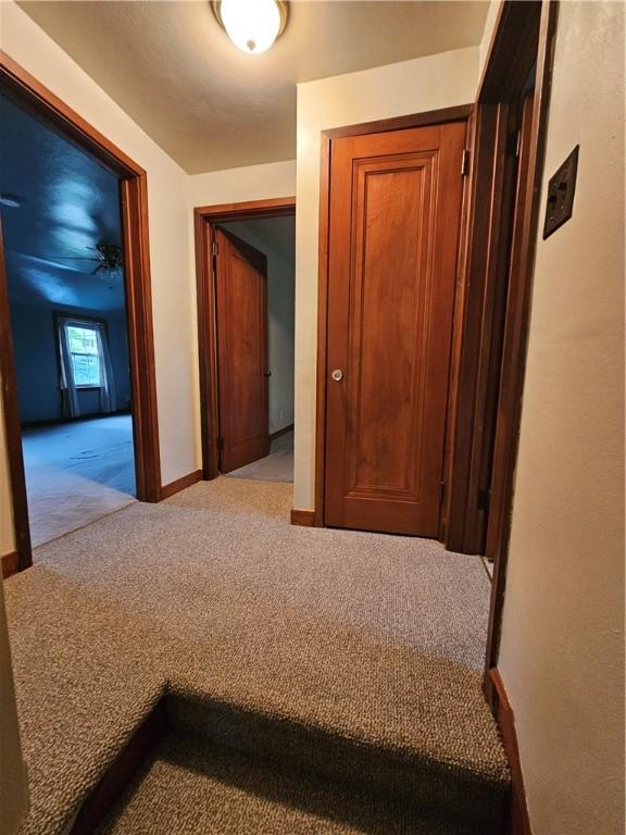 hallway with carpet and baseboards