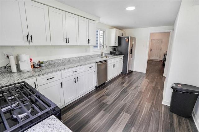 1318 Louise St, Munhall, PA 15120 - kitchen featuring appliances with stainless steel finishes, a sink, white cabinets, light stone counters, and dark wood finished floors