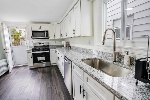 1318 Louise St, Munhall, PA 15120 - kitchen featuring stainless steel appliances, a sink, dark wood finished floors, white cabinetry, and radiator heating unit