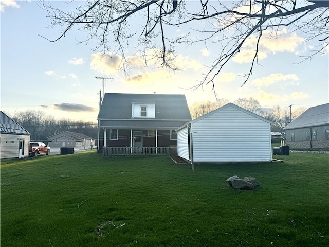 rear view of house featuring a yard and a porch