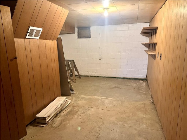 finished below grade area featuring visible vents and concrete block wall