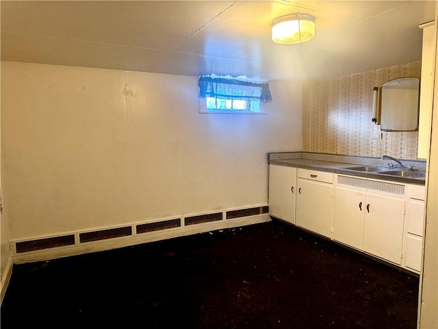 kitchen featuring white cabinets, concrete floors, and a sink