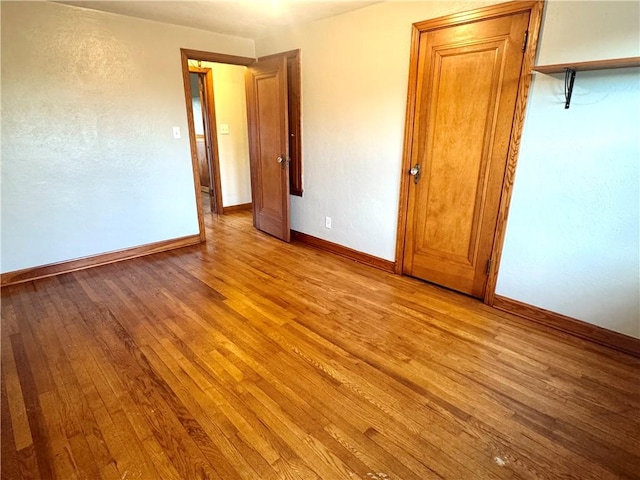 spare room featuring baseboards and light wood-style flooring