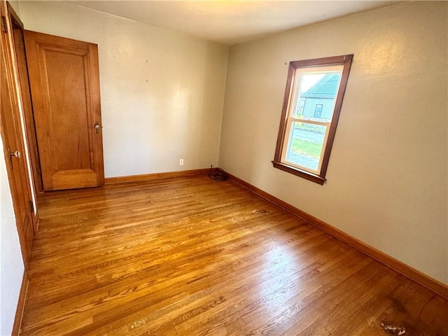 spare room with light wood-type flooring and baseboards