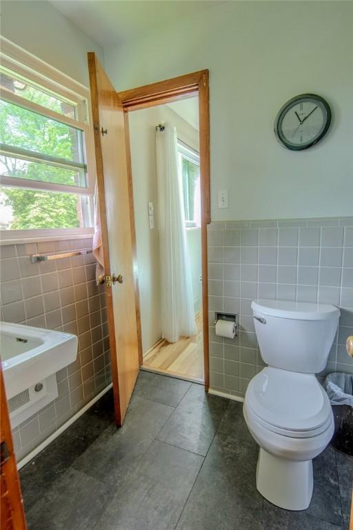 1898 Brushcliff Rd, Churchill Boro, PA 15221 - bathroom featuring a wainscoted wall, tile patterned flooring, tile walls, and toilet