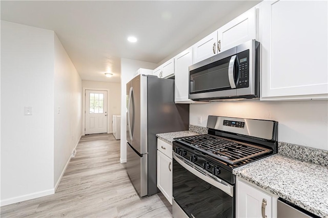 kitchen featuring light wood finished floors, white cabinets, and appliances with stainless steel finishes