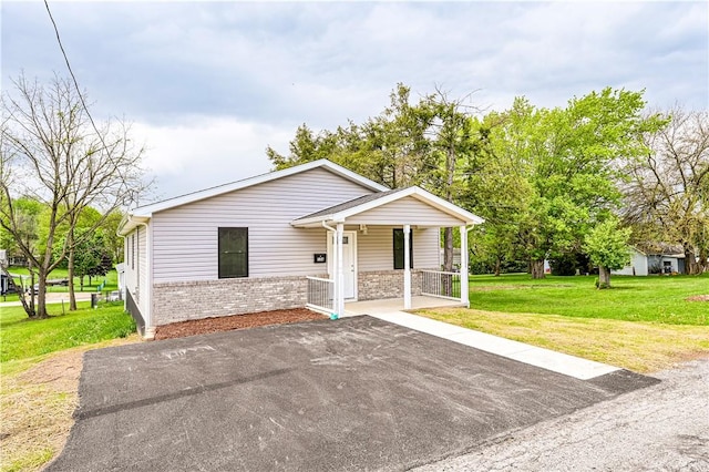 view of front of property with a porch, brick siding, and a front yard